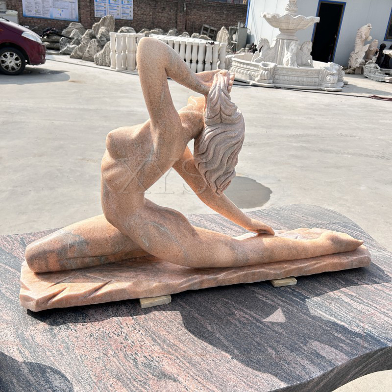 Escultura de niña de yoga de piedra roja al atardecer