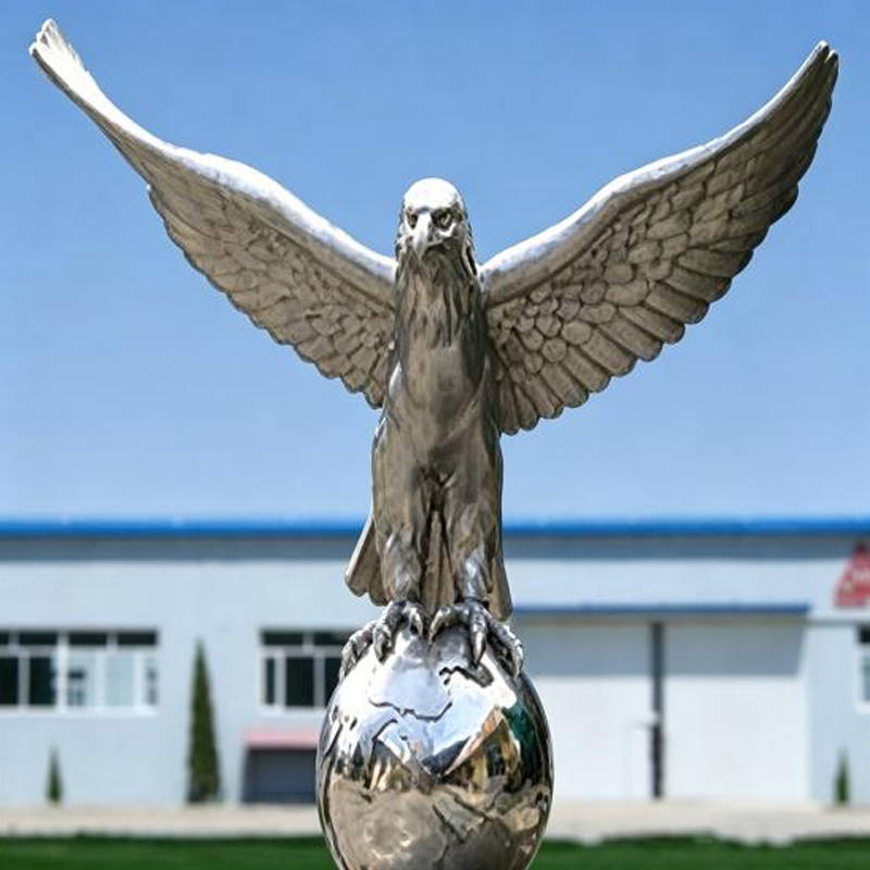 Escultura realista de águila en globo terráqueo de acero inoxidable