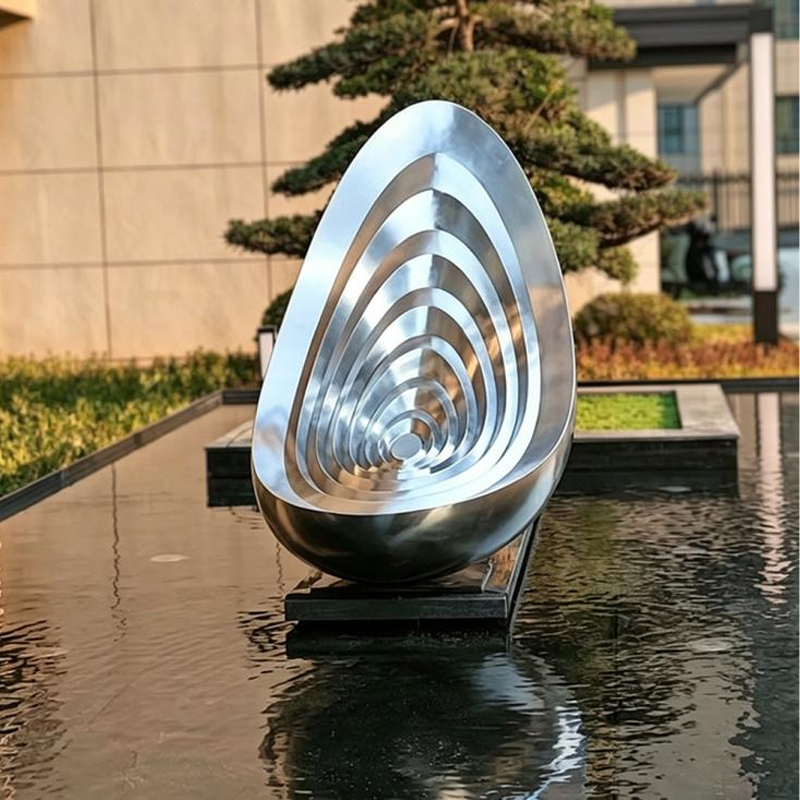 Escultura de acero inoxidable con forma de gota de agua ondulada